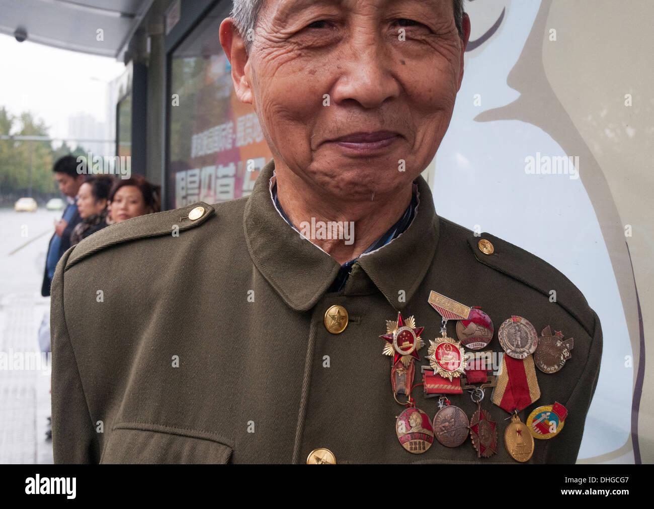 Eine ältere Figur in Chengdu zeigt seine Sammlung der Mao-Ära Medaillen und Abzeichen Stockfoto