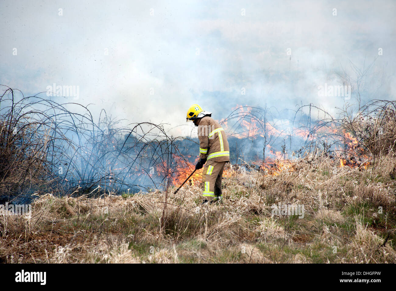 Feuerwehrmann mit Schlägern auf Grass Feuer Heide Stockfoto