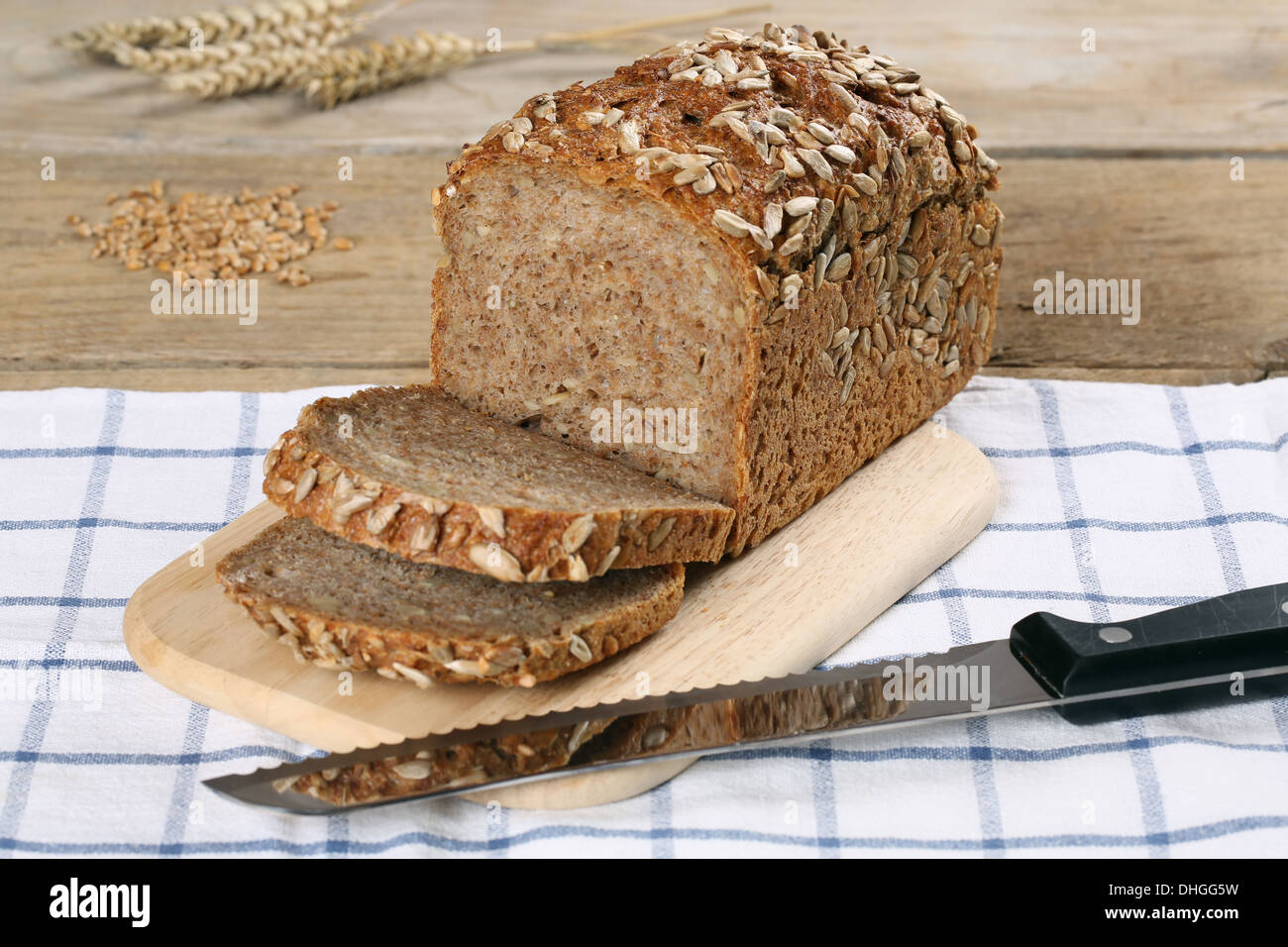 Frisches Vollkornbrot auf einem Holzbrett und einem Brotmesser Stockfoto