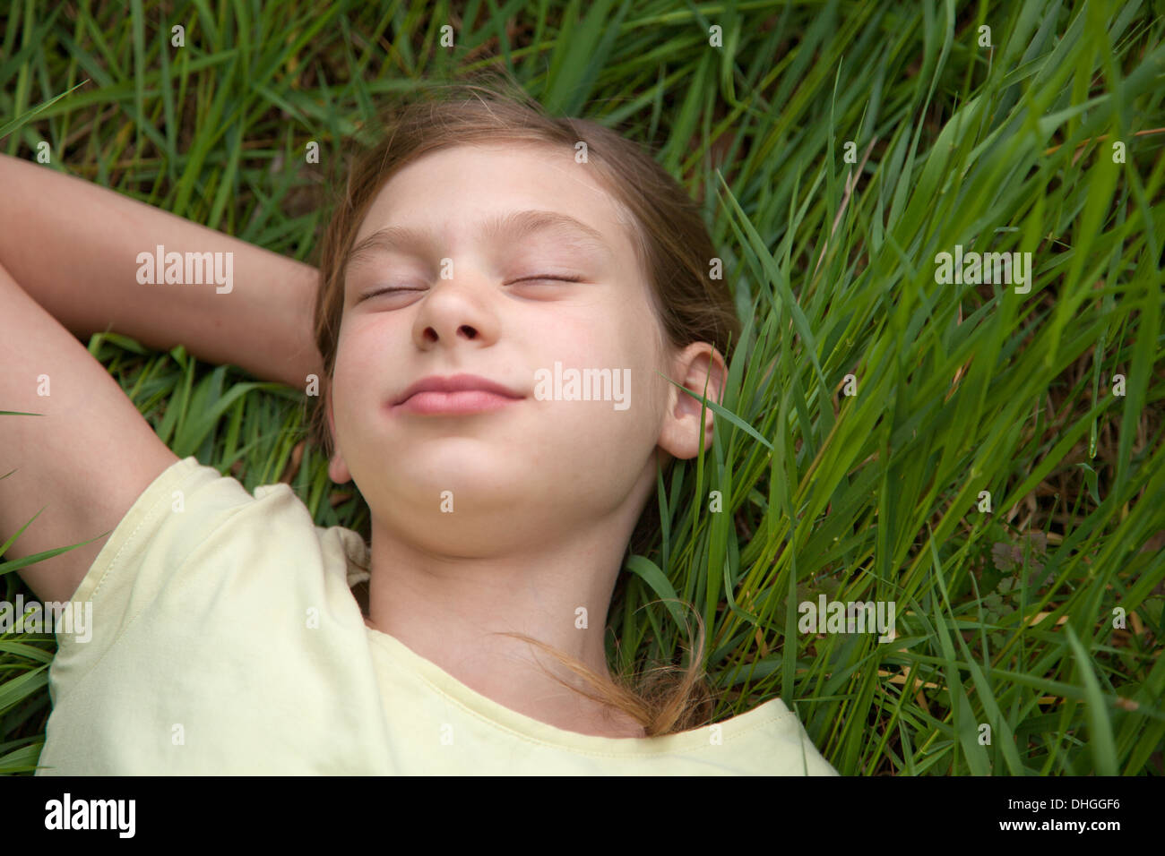 Kind, das auf der grünen Wiese in der Natur Stockfoto