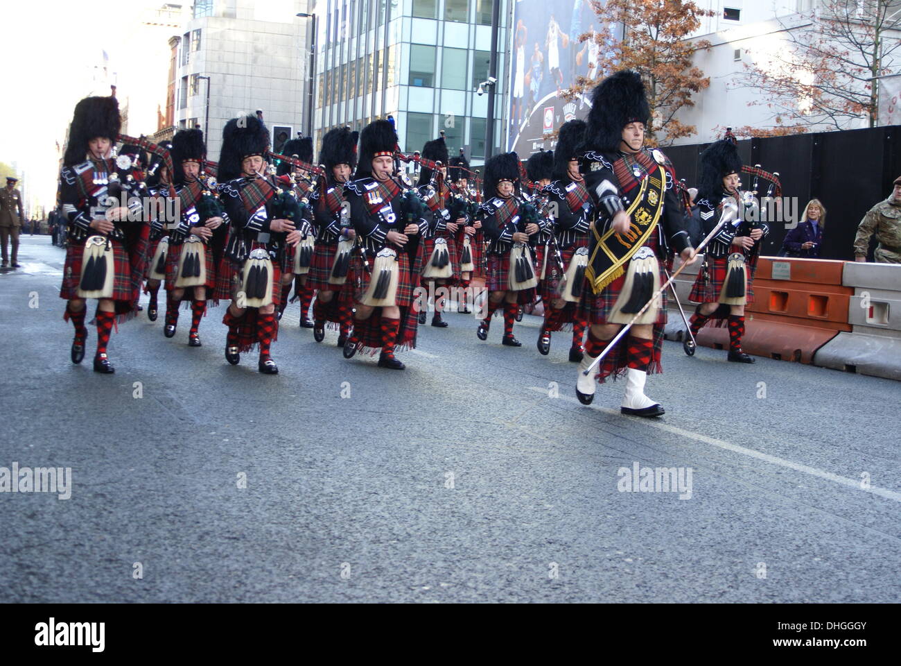 Eine Pipe Band führt militärische Personal und Kriegsveteranen zu den Kenotaph in Manchester UK zu jener gedenken, die in vergangenen Kriegen und Konflikten gestorben. Sonntag, 10. November 2013 Stockfoto