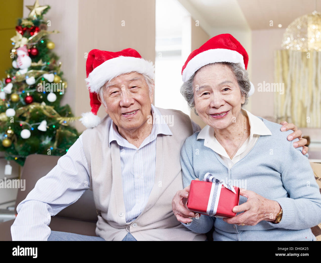 Porträt von einem asiatischen älteres Paar mit Weihnachtsmützen und Geschenke. Stockfoto