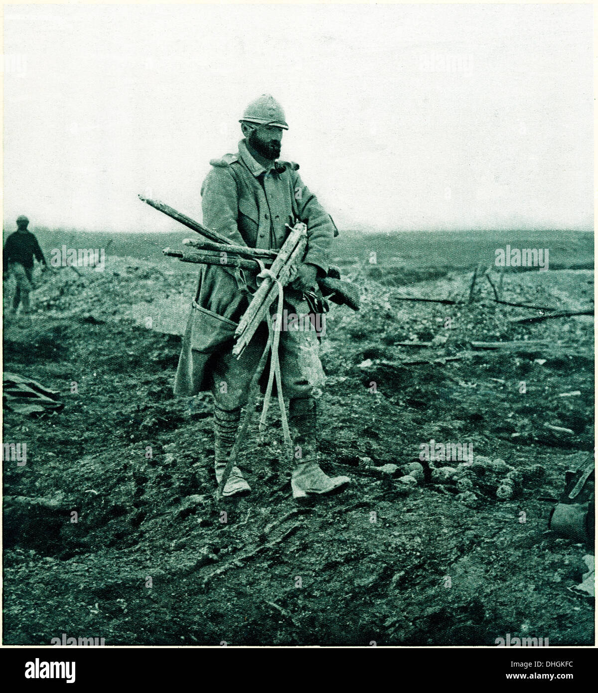 Poilu. ein französischer Infanterist sammelt gebrauchte Defekte Gewehre aus dem zerstörten Schlachtfeld von der Westfront Stockfoto