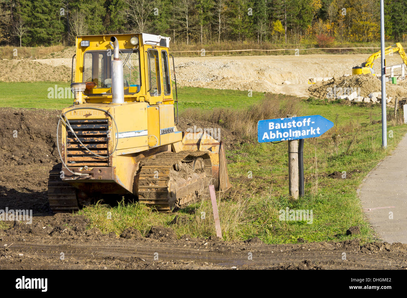 Crawler Fahrzeug und Finger Post an deutschen Baumarkt-Materialien. Stockfoto