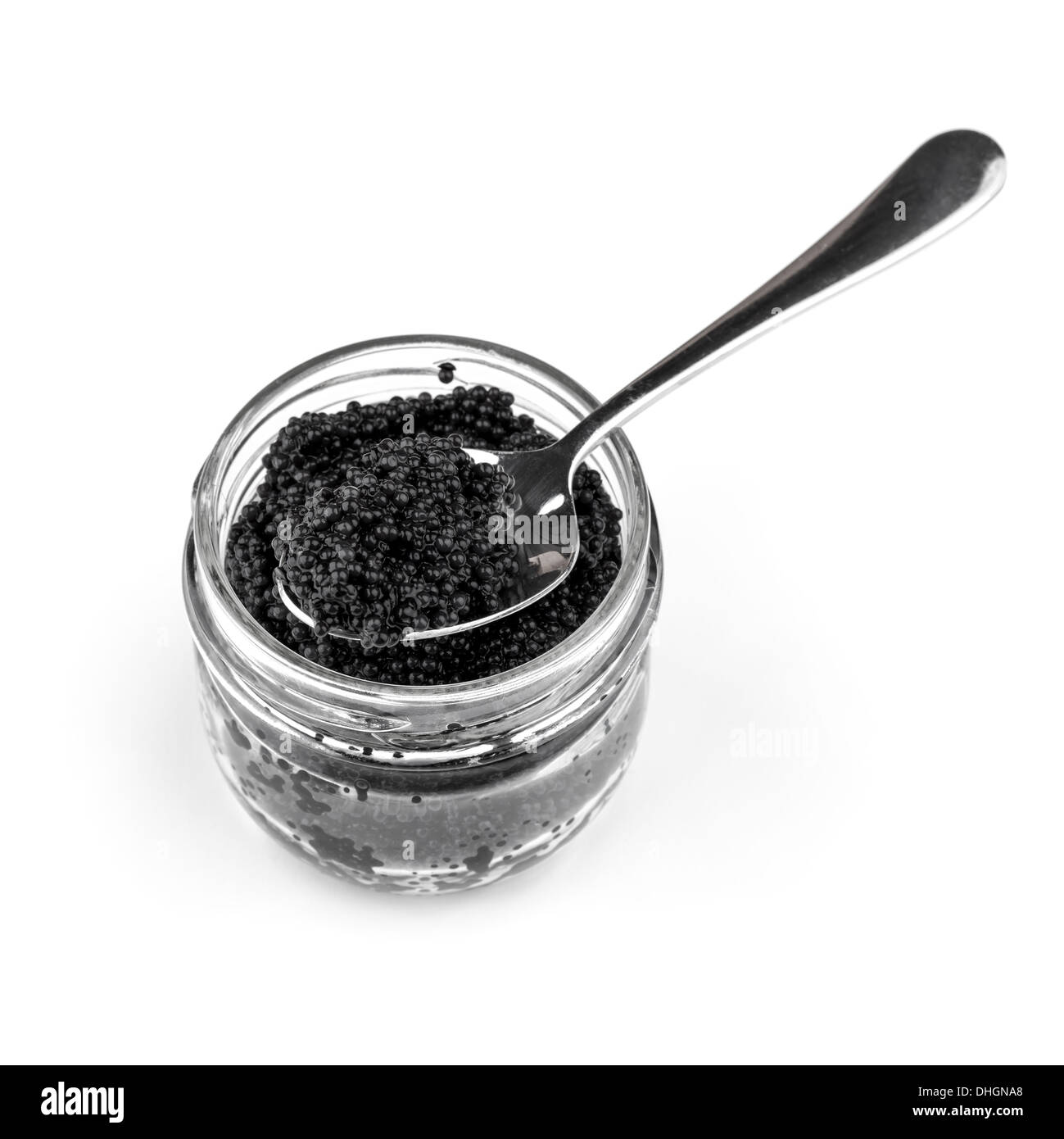 Schwarzer Kaviar in ein Glas mit einem Teelöffel isoliert auf weißem Hintergrund Stockfoto