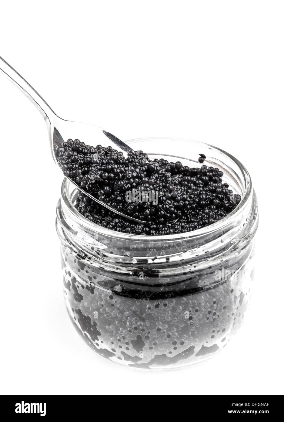 Schwarzer Kaviar in einem Glas mit Löffel isoliert auf weißem Hintergrund Stockfoto