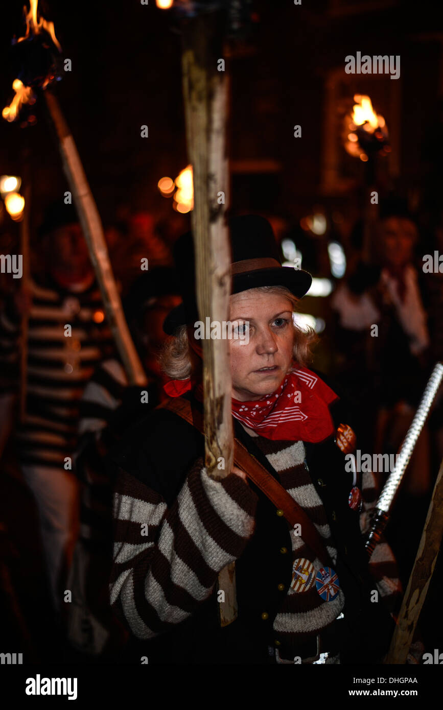 Frau in gestreiften Oberteil und Hut in Lagerfeuer-Prozession Stockfoto