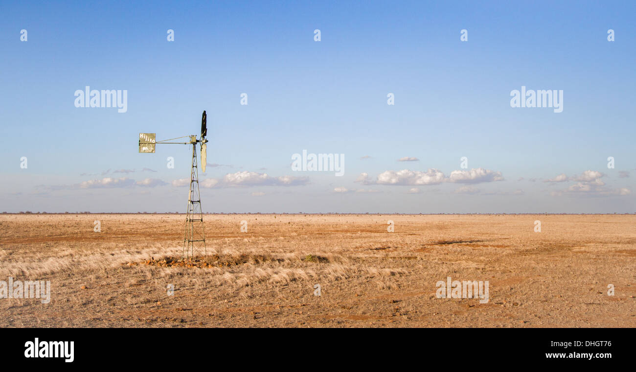 Isolierte Wind Pumpe Fütterung ein Wasserloch im Grassland ausgedörrte Savanne des Tsavo East National Park im Süden Kenias Stockfoto