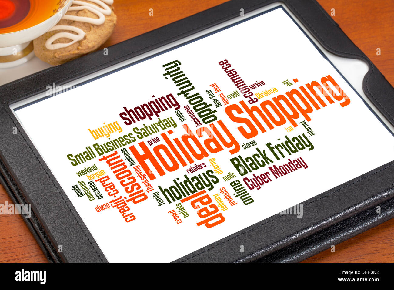 Weihnachtseinkäufe Wortwolke auf digitale Tablett mit einer Tasse Tee und Cookies Stockfoto