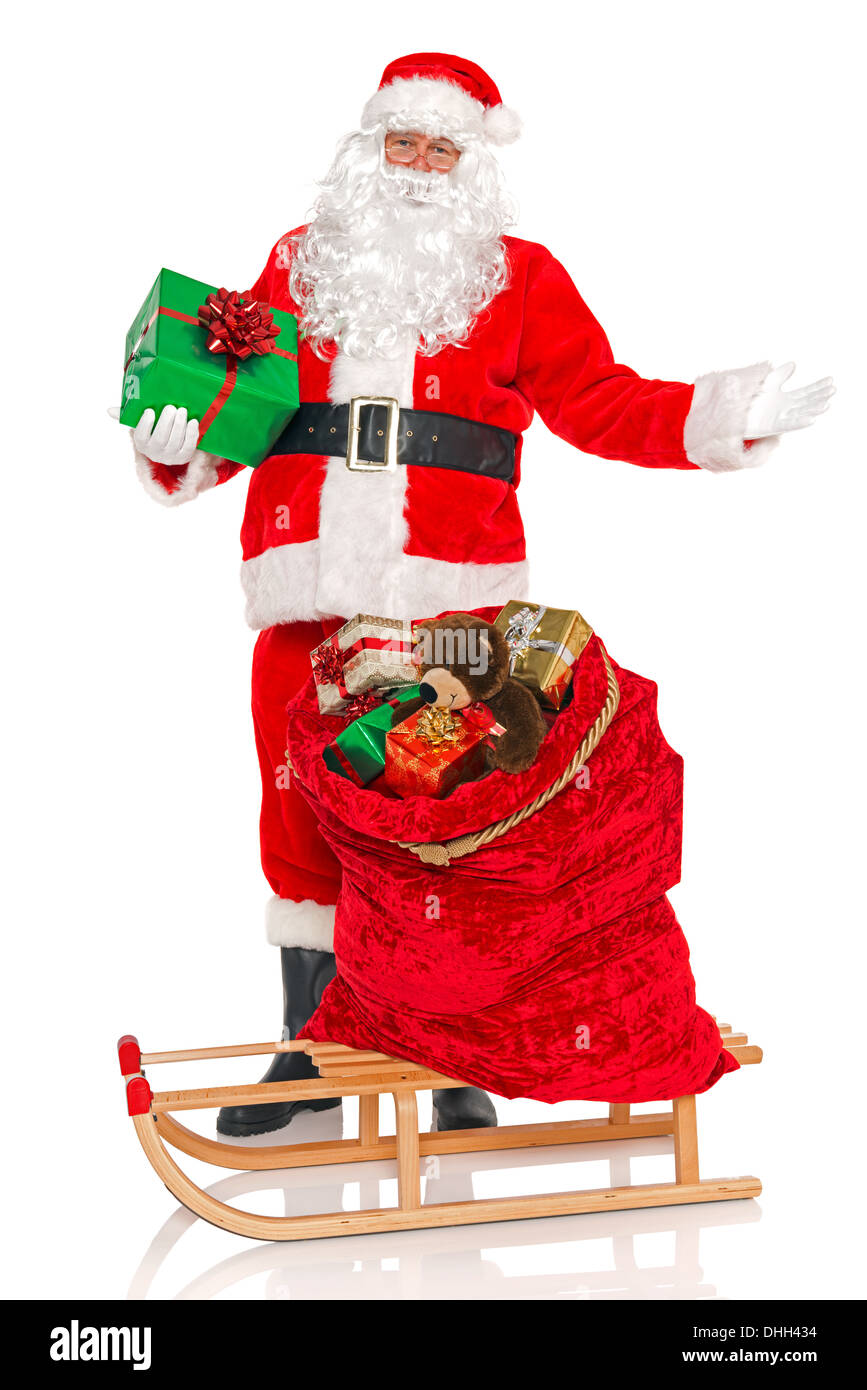 Weihnachtsmann einen Sack voller Geschenk Spielzeug verpackt und präsentiert auf einem Schlitten, isoliert auf einem weißen Hintergrund. Stockfoto