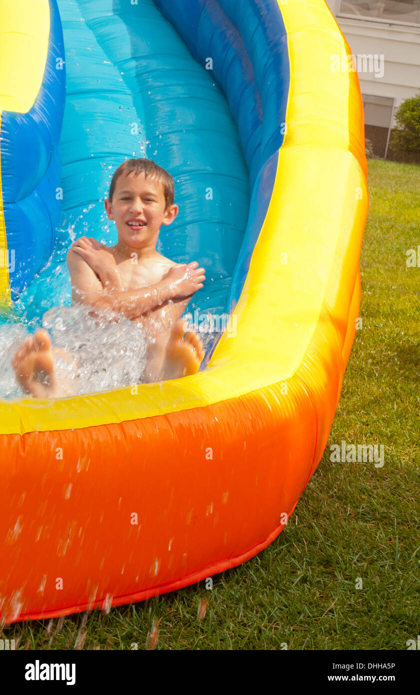 Familie Wasser Folie auf der Rückseite Hof zu Hause mit Wasser im Sommer und jungen im Alter von 10 spielen und Spaß Stockfoto