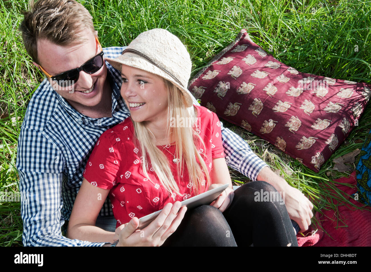 Junges Paar sitzt auf der Picknickdecke mit digital-Tablette Stockfoto