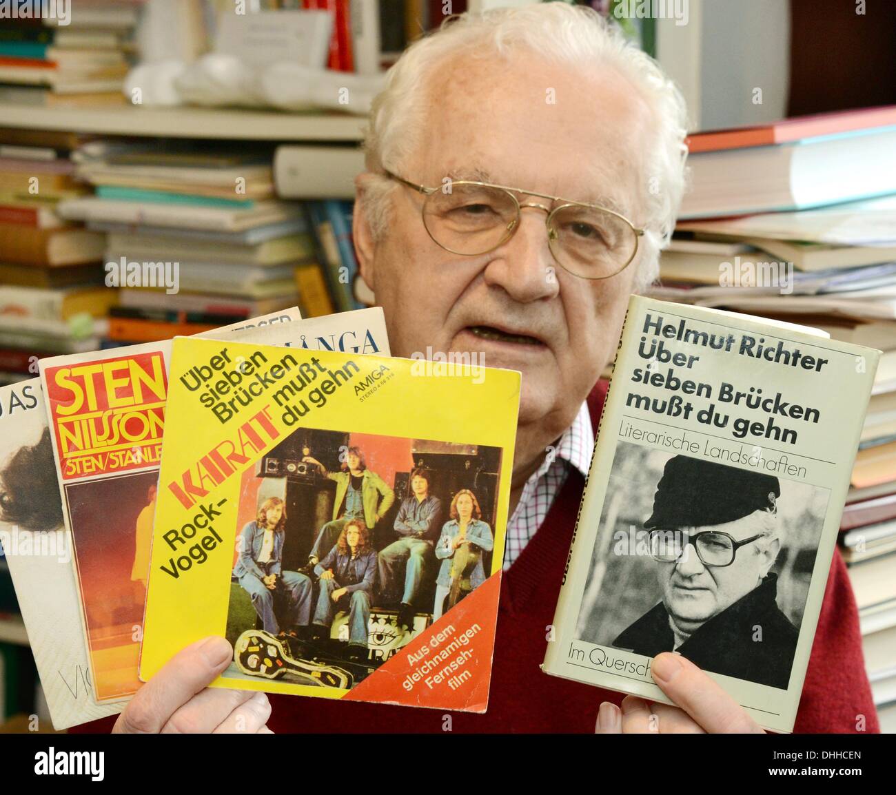 Deutscher Liedermacher und Autor Helmut Richter hält sein Buch "Schlug Sieben Tisches aufgefrischt du Weltenverbindens" ("Sie müssen Kreuz sieben Brücken", R) und LPs des Liedes in seiner Wohnung in Leipzig, Deutschland, 8. November 2013. Helmut Richter, der am 30. November 2013 seinen 80. Geburtstag feiert, schrieb das Lied "Schlug Sieben Tisches aufgefrischt du Weltenverbindens" ("Sie müssen Kreuz sieben Brücken"). Im Jahr 1978 wurde das Lied gespielt von der deutschen Band Karat und Popularität über die deutschen Grenzen hinweg. Vor allem als westdeutscher Sänger Peter Maffay eine Coverversion des Songs aufgenommen wurde es im Jahr 1980 ein Riesenhit für ihn. Pho Stockfoto Deutscher Liedermacher und Autor Helmut Richter hält sein Buch "Schlug Sieben Tisches aufgefrischt du Weltenverbindens" ("Sie müssen Kreuz sieben Brücken", R) und LPs des Liedes in seiner Wohnung in Leipzig, Deutschland, 8. November 2013. Helmut Richter, der am 30. November 2013 seinen 80. Geburtstag feiert, schrieb das Lied "Schlug Sieben Tisches aufgefrischt du Weltenverbindens" ("Sie müssen Kreuz sieben Brücken"). Im Jahr 1978 wurde das Lied gespielt von der deutschen Band Karat und Popularität über die deutschen Grenzen hinweg. Vor allem als westdeutscher Sänger Peter Maffay eine Coverversion des Songs aufgenommen wurde es im Jahr 1980 ein Riesenhit für ihn. Pho Stockfoto