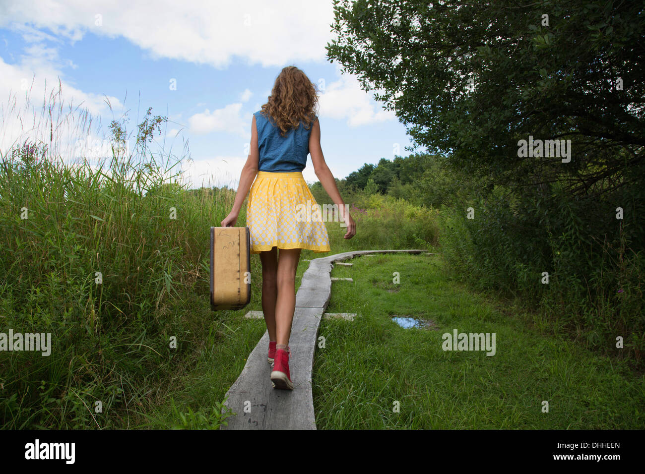 Teenager-Mädchen tragen Koffer auf ländlichen Weg Stockfoto