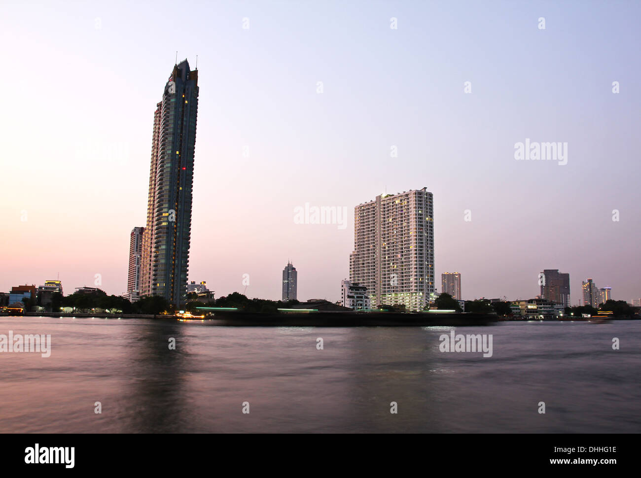 Gebäude entlang des Flusses bei Sonnenuntergang. Die Aussicht vom Asiatique. Sehenswürdigkeiten in Bangkok, Thailand. Stockfoto