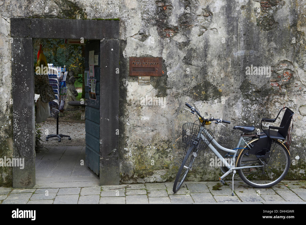 Der Eingang zu den botanischen Gärten in Lucca Toskana Italien. Eine diskrete Tür in einer alten Wand mit einem Fahrrad davor Stockfoto