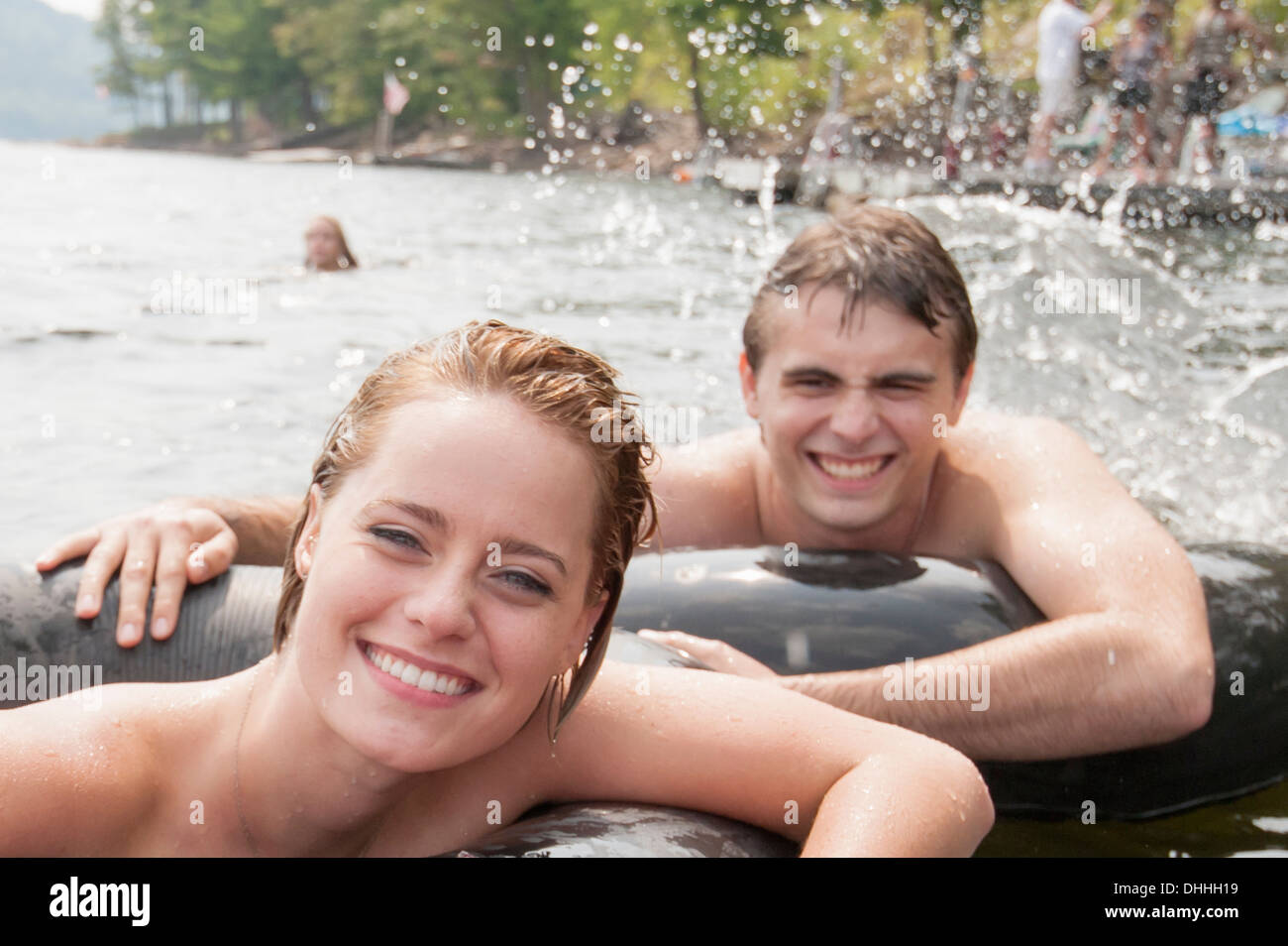 Junges Paar im aufblasbaren Ringen schweben Stockfoto