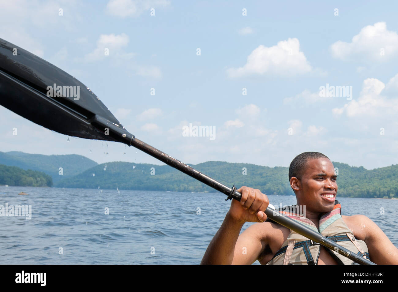 Junger Mann tragen Schwimmweste hält Ruder Stockfoto