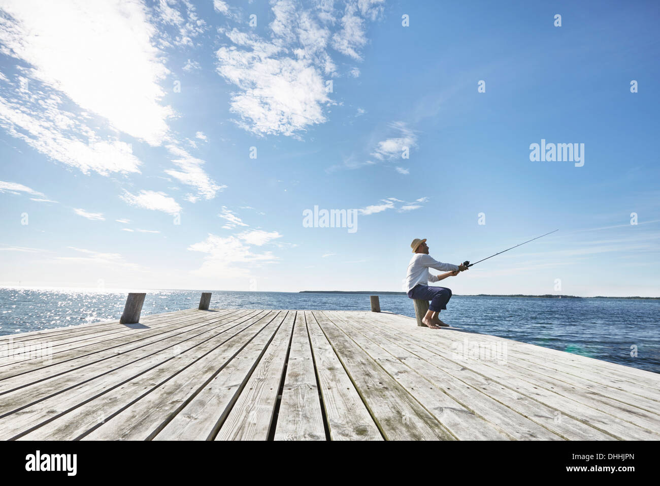 Mitte erwachsener Mann Angeln an Pier, Utvalnas, Schweden Stockfoto