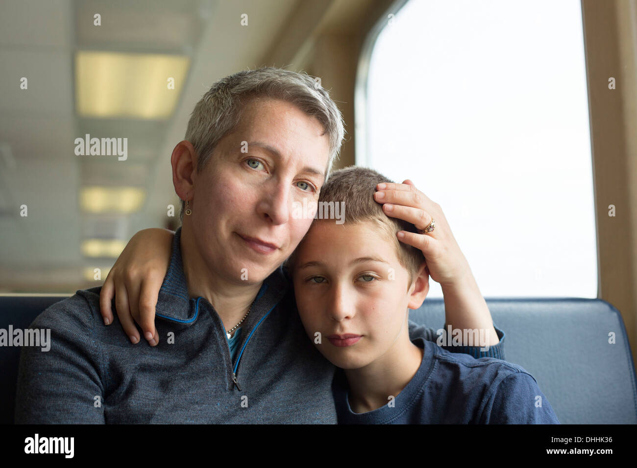 Mutter und Sohn sitzen zusammen mit Arm um Stockfoto