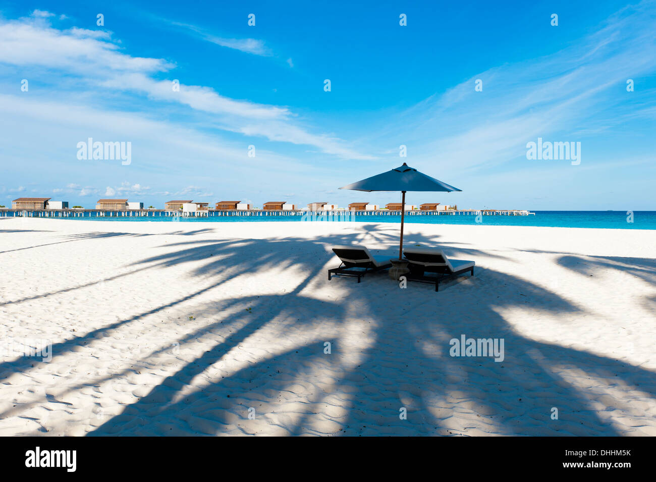 Strand mit Sonnenschirm und Blick auf Wasservillen im Park Hyatt Maldives Hadahaa, Gaafu Alifu Atoll, Nord-Huvadhoo-Atoll, Malediven Stockfoto