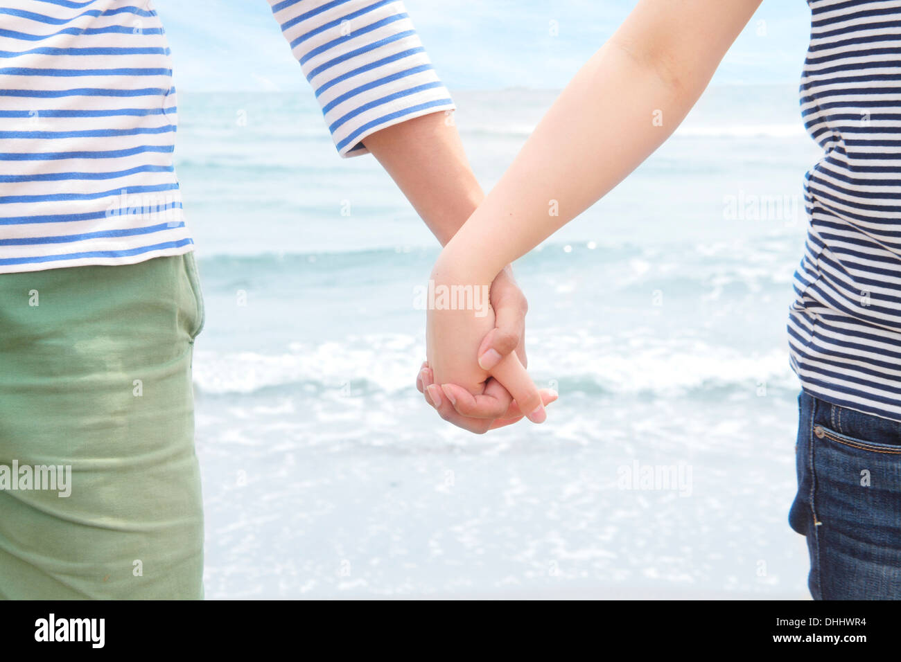 Junges Paar Hand in Hand vor Meer Stockfoto