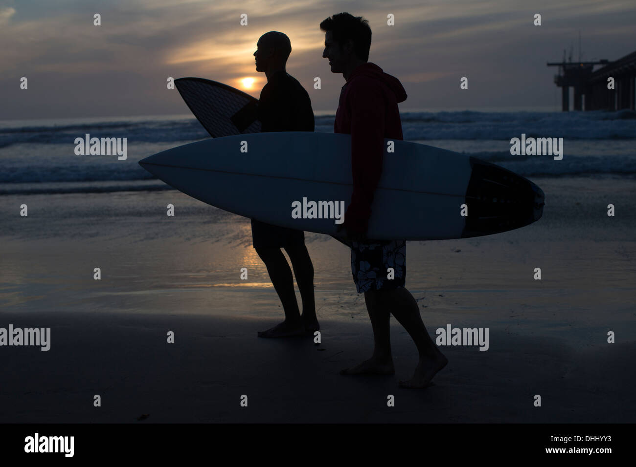 Surfer am Strand von Silhouette Stockfoto