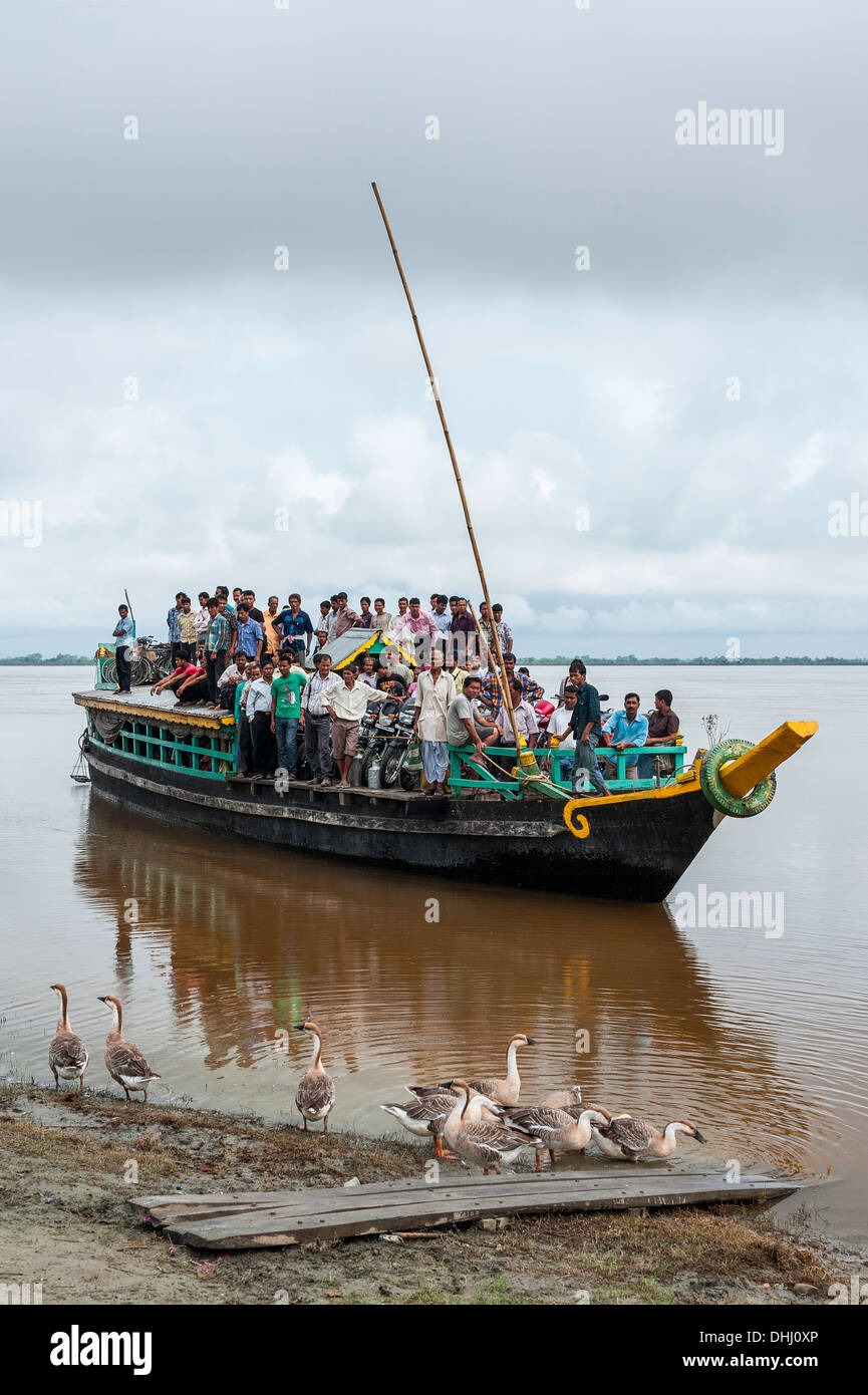 Überfüllte Fähre kommt am Nimati Ghat von Majuli Insel überquert den Brahmaputra Fluss in der Nähe von Jorhat, Assam. Stockfoto