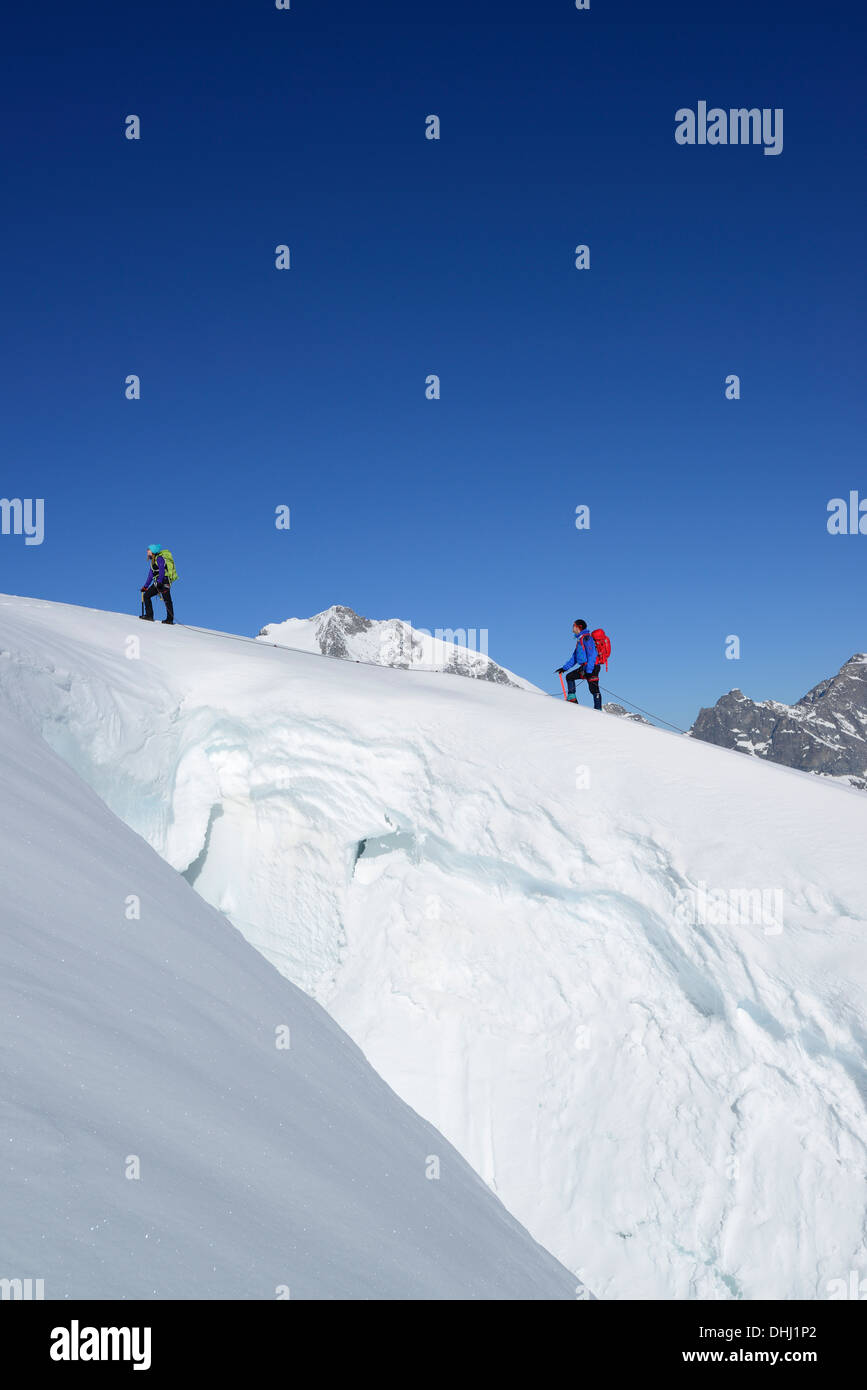 Zwei Bergsteiger aufsteigend vor eine Gletscherspalte, Piz Palue, Graubünden, Schweiz Stockfoto
