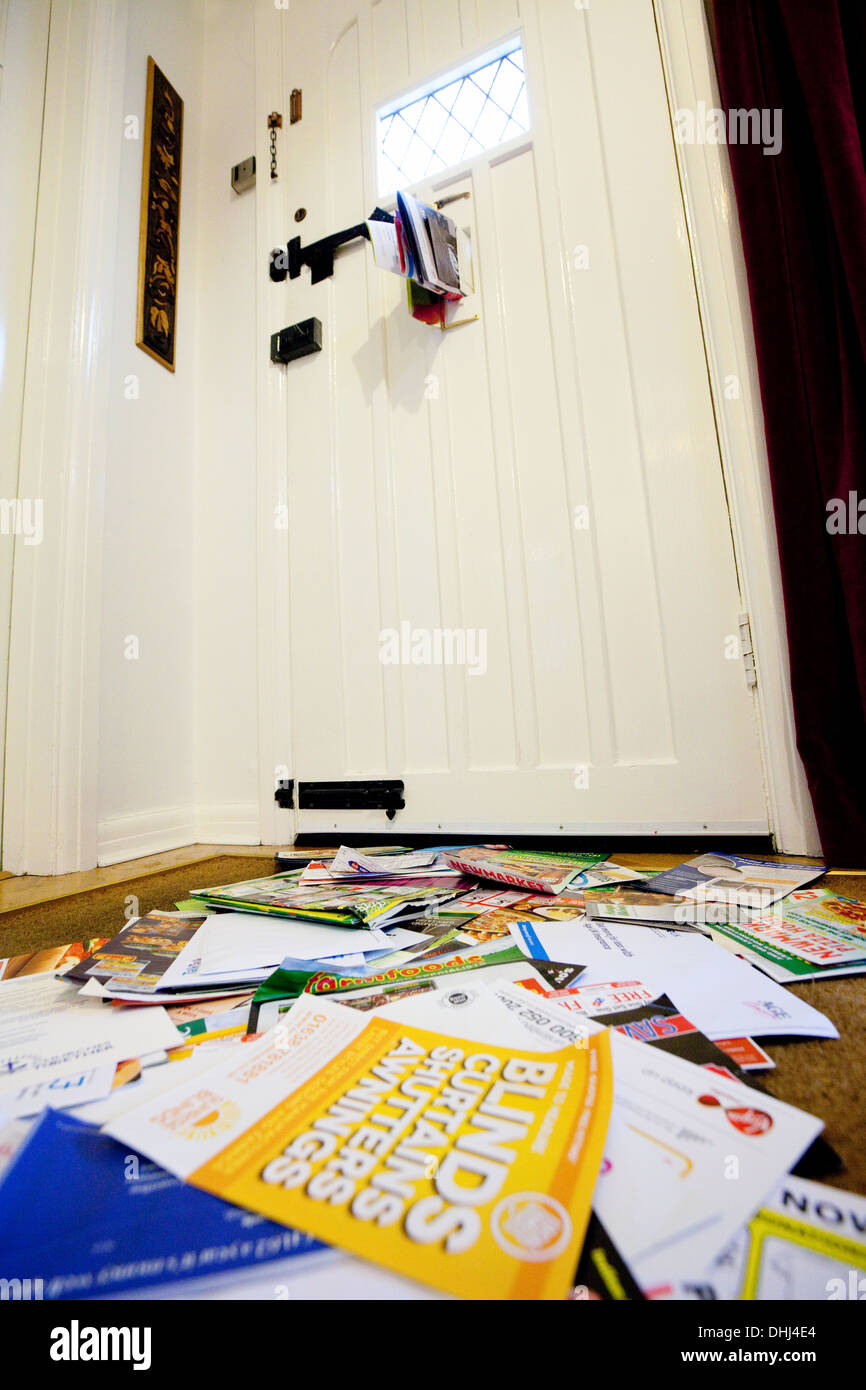 Junk-Mail gepostet in den Briefkasten und auf der Fußmatte zu Hause, England UK Stockfoto