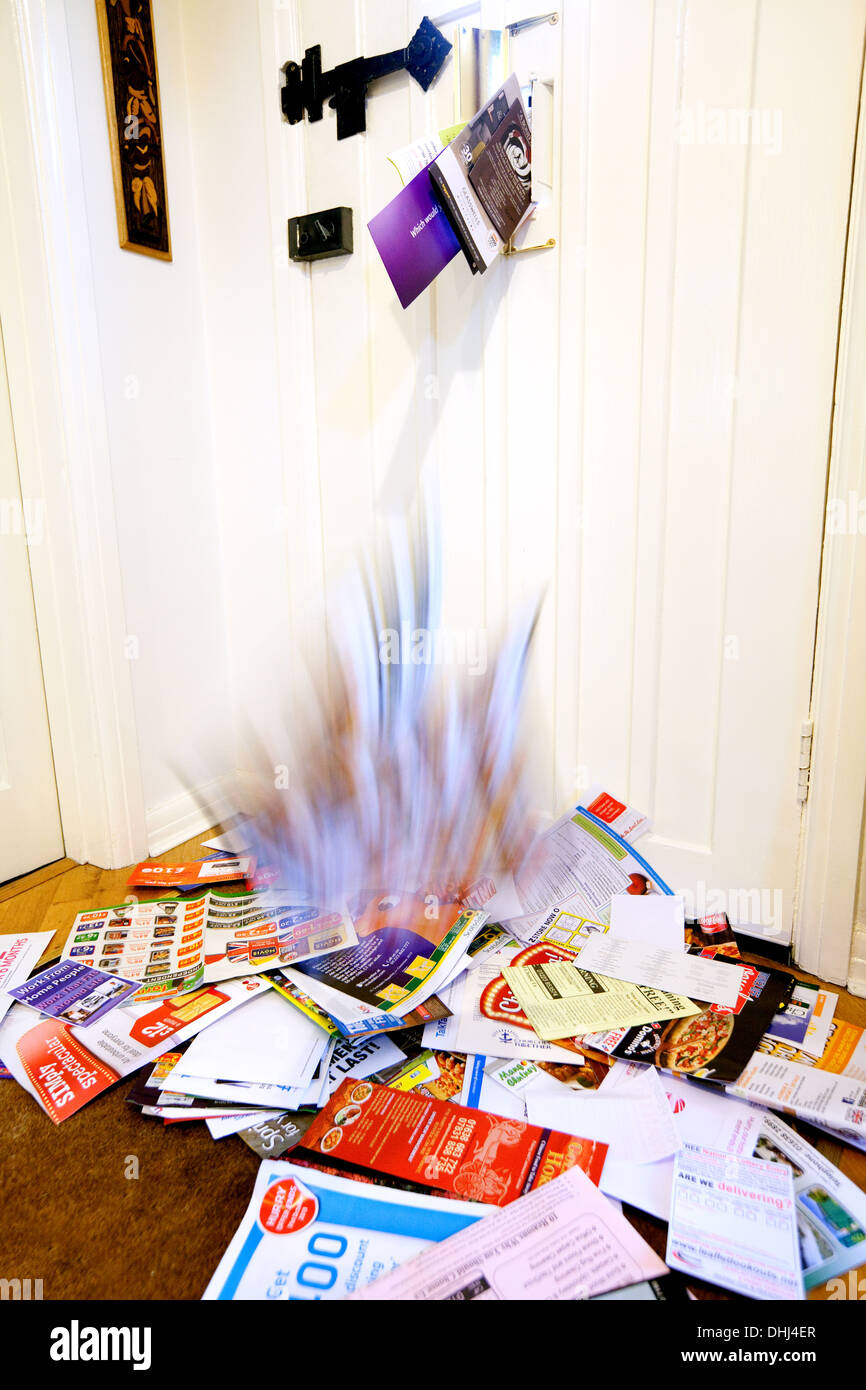 Junk-Mail fällt durch den Briefkasten auf der Fußmatte zu Hause, England UK Stockfoto