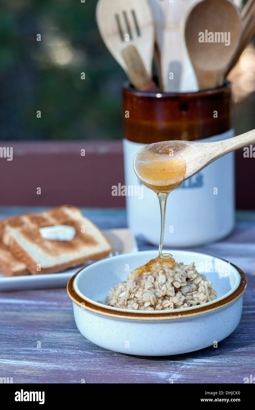 Löffel Honig auf Haferflocken. Stockfoto