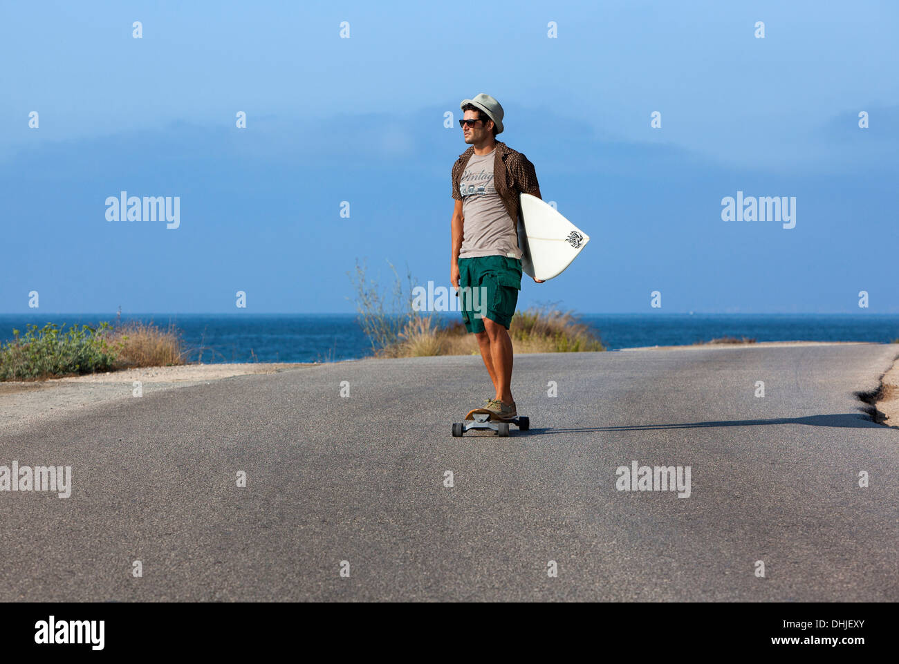 Junge mit Hut und seinem Surfbrett Skaten Stockfoto