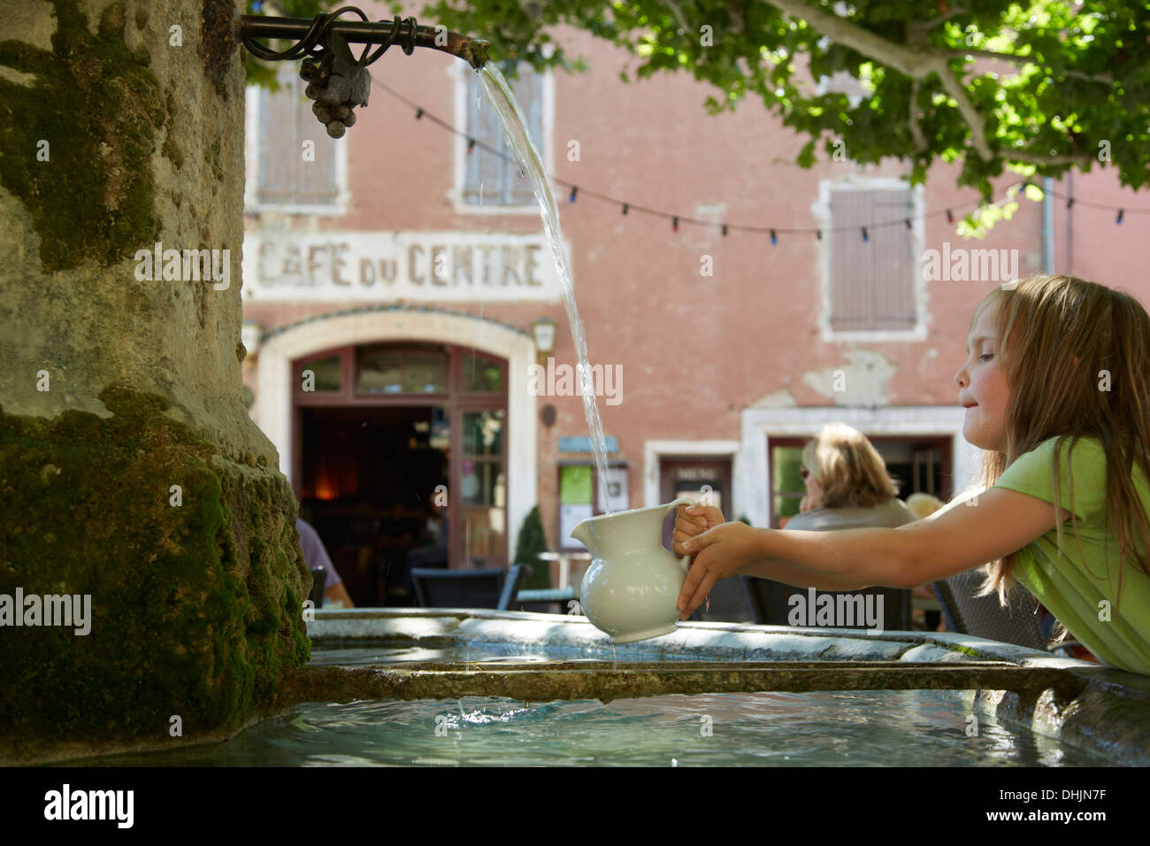 Frankreich, Provence, Vaucluse, Villedieu, kleines Mädchen unter Wasser aus einem Brunnen Stockfoto