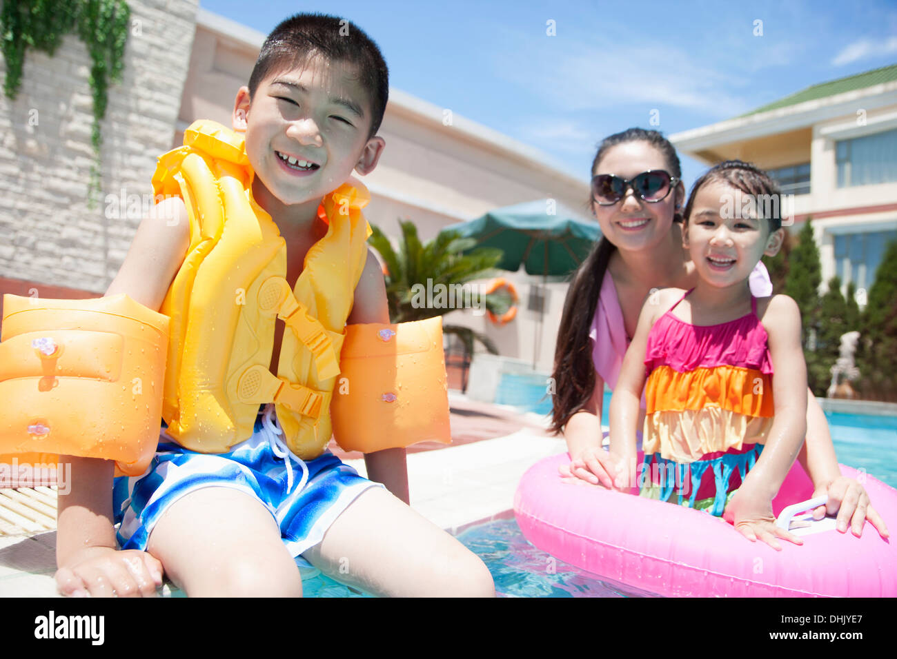 Familienporträt, Mutter, Tochter und Sohn, am Pool mit Wasserspielzeug Stockfoto
