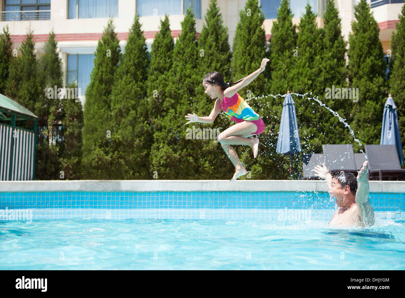 Vater Tochter zu werfen, in den Pool, mitten in der Luft Stockfoto