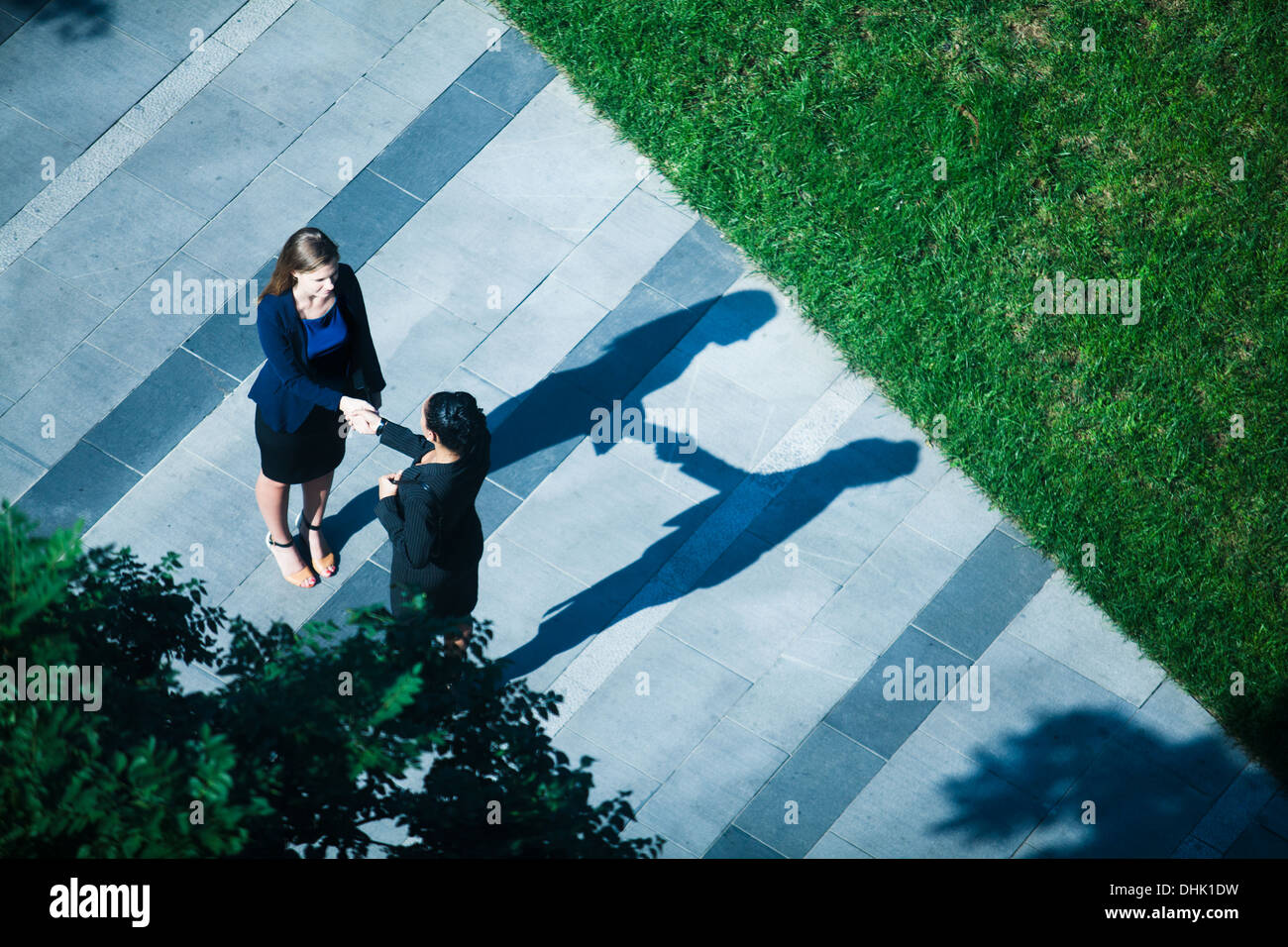 Luftaufnahme von zwei Geschäftsfrauen Händeschütteln auf dem Bürgersteig Stockfoto