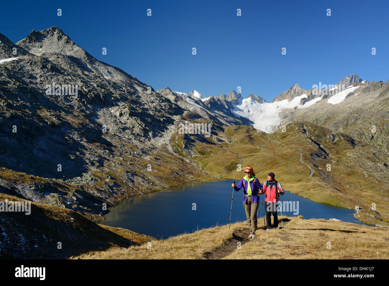 Frau und Mann in der Nähe von einem Bergsee mit Blick zum Oberaarhorn und Finsteraarhorn, Berner Alpen, Berner Oberland, UNESCO Wo Wandern Stockfoto