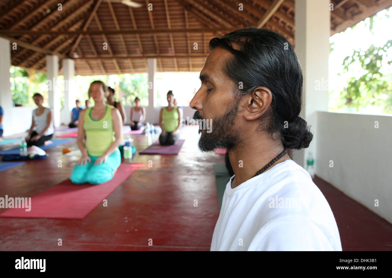 Yogalehrer mit seinen Schülern in Varkala, Indien zu meditieren. Stockfoto