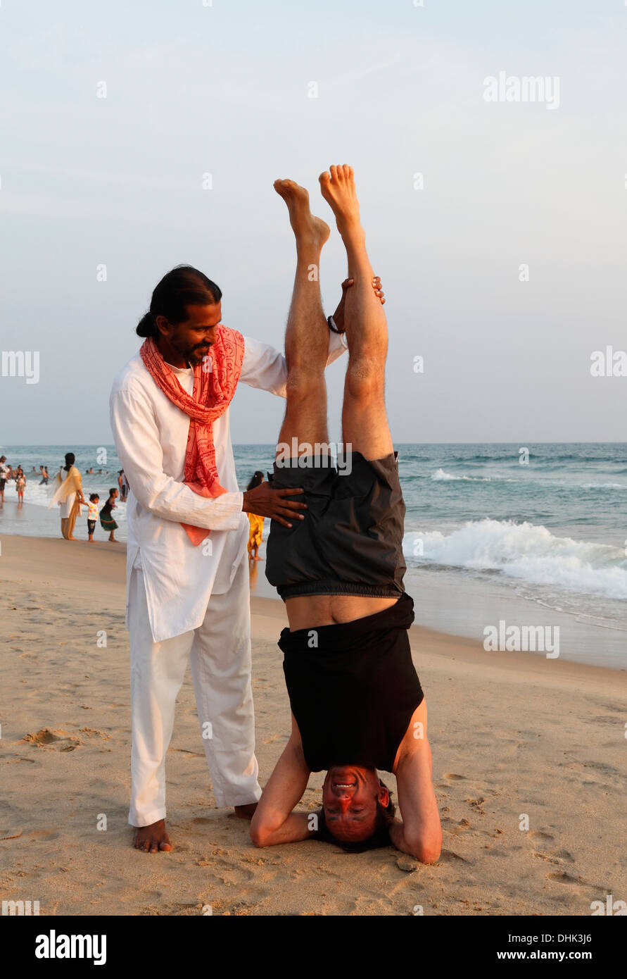 Indische Yoga-Lehrer und Schüler am Strand in Varkala, Indien. Stockfoto