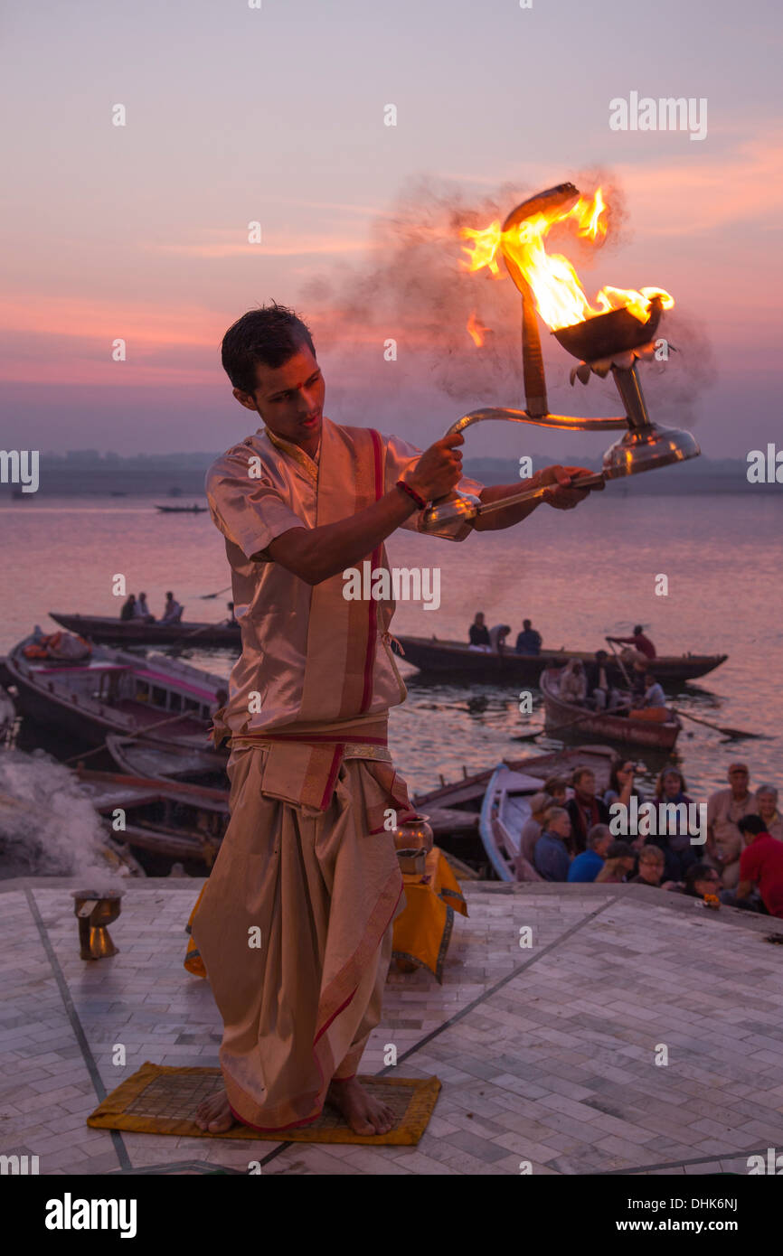 Hindu-Mönch führt Gebetszeremonie am Dasaswamedh Ghat neben Fluss Ganges bei Sonnenaufgang, Varanasi, Uttar Pradesh, Indien Stockfoto