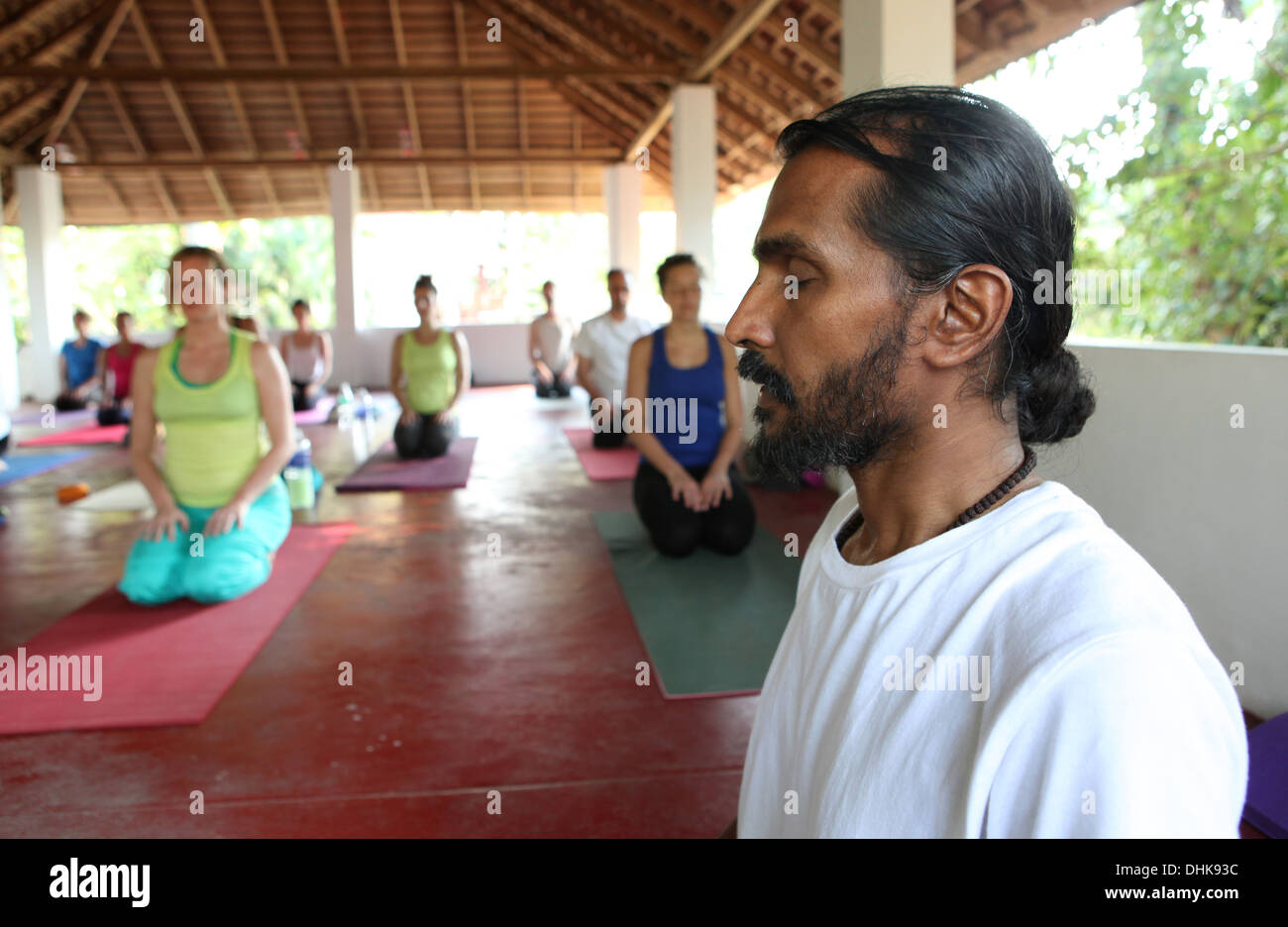 Yogalehrer mit seinen Schülern in Varkala, Indien zu meditieren. Stockfoto