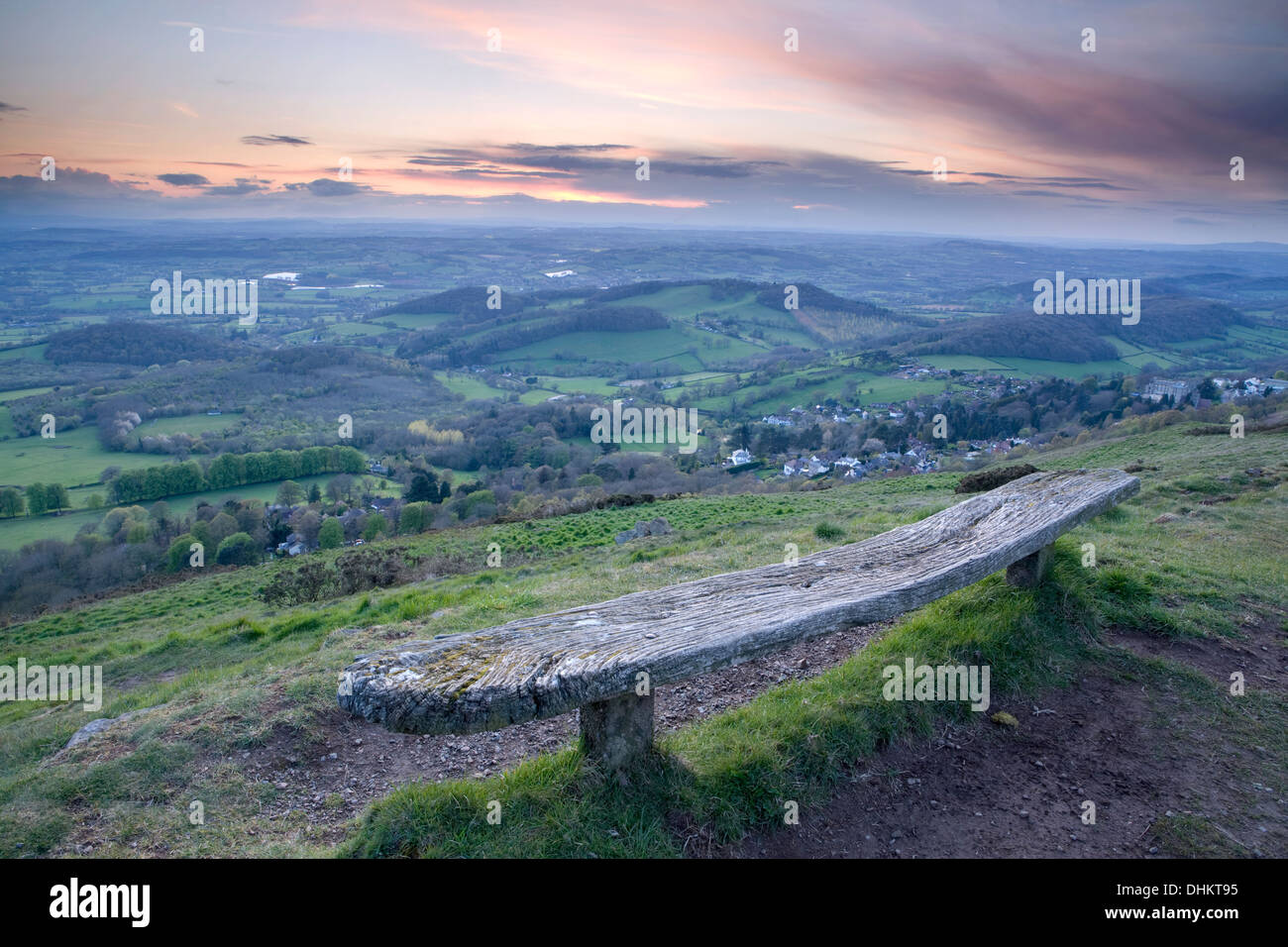 Eine alte verwitterte Holzbank auf der Westseite der Worcesteshire Leuchtturm, Malvern, bei Sonnenuntergang. Stockfoto