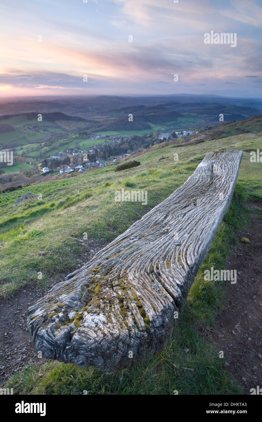 Eine alte verwitterte Holzbank auf der Westseite der Worcesteshire Leuchtturm, Malvern, bei Sonnenuntergang. Stockfoto