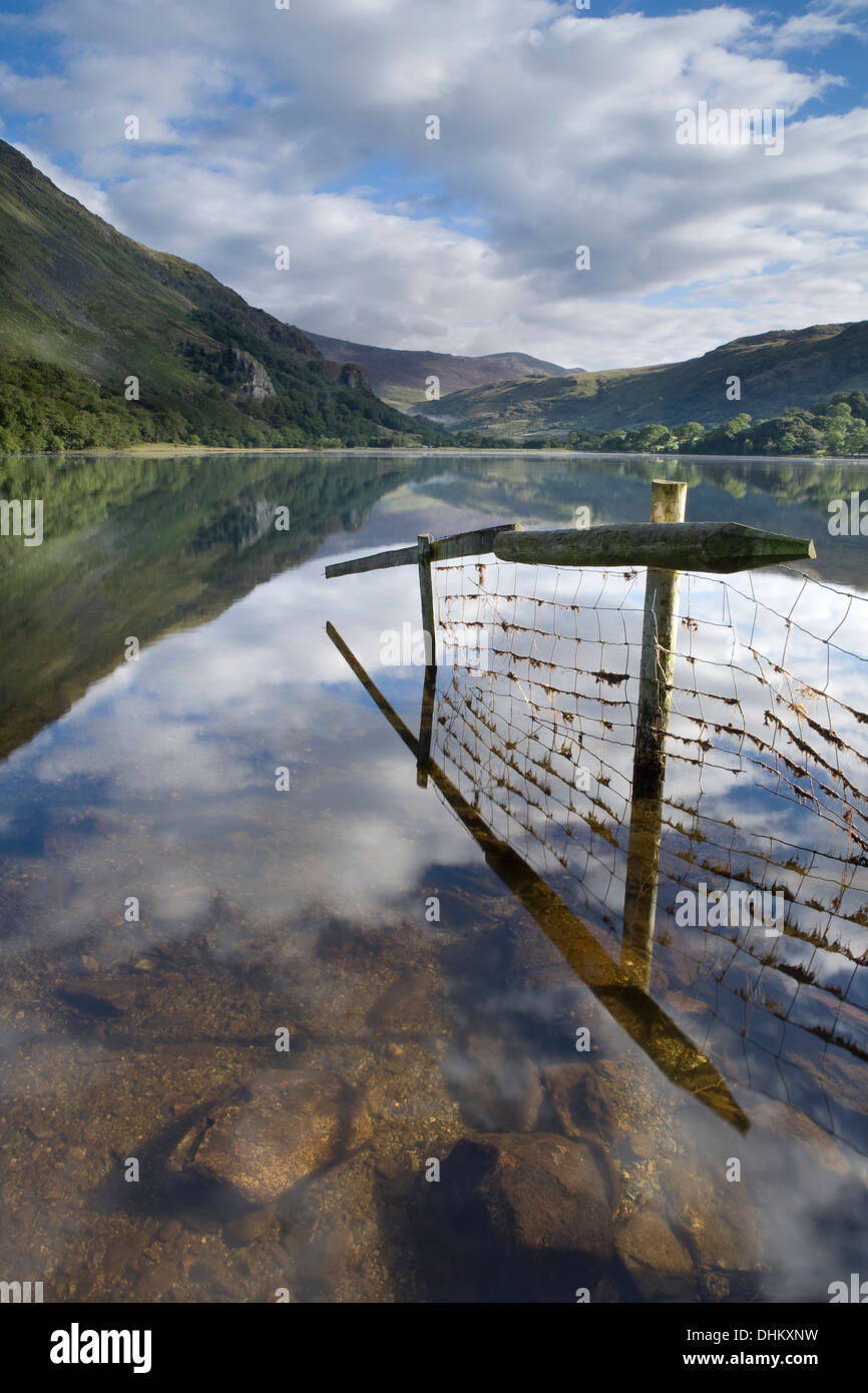 Bild von einem Zaun und Reflexion in Llyn Gwynant gehen. Der Nebel steigt über dem See teilweise verdeckt Gallt y Wenallt. Stockfoto