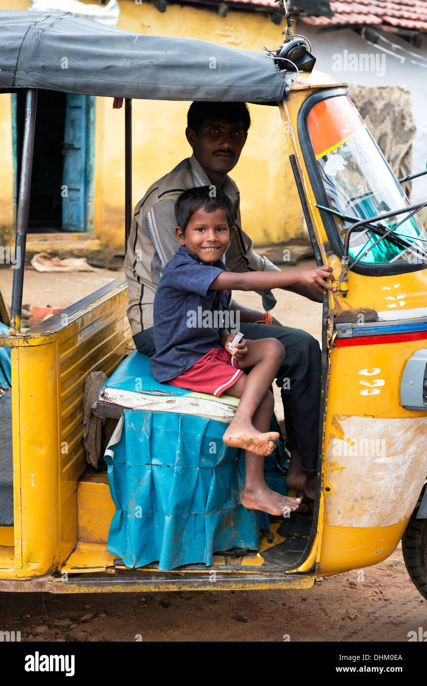 Indische Vater und Sohn saß in einer Rikscha lächelnd in einem indischen Dorf. Andhra Pradesh, Indien Stockfoto