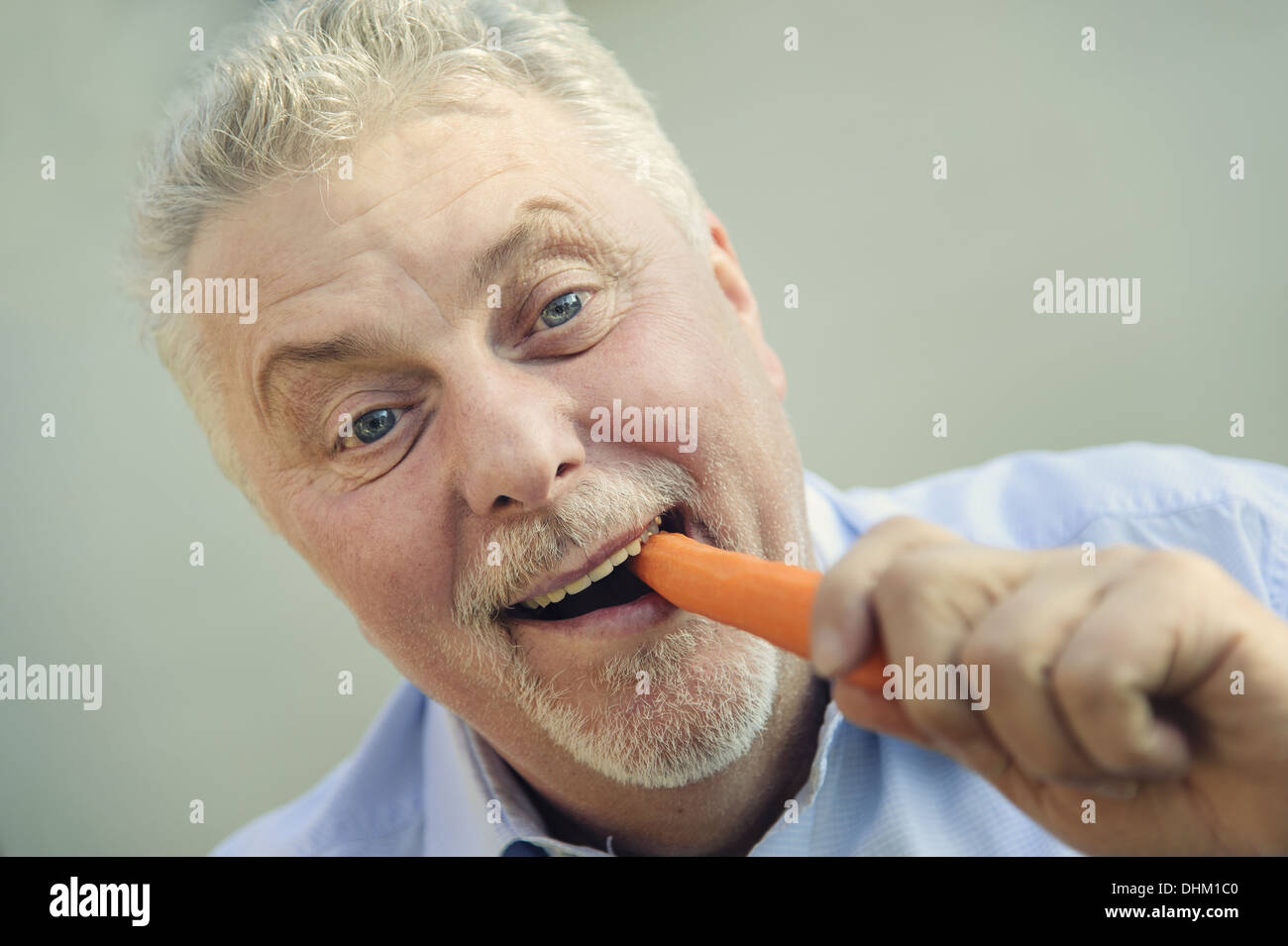 ein Senior isst gerne eine Möhre Stockfoto