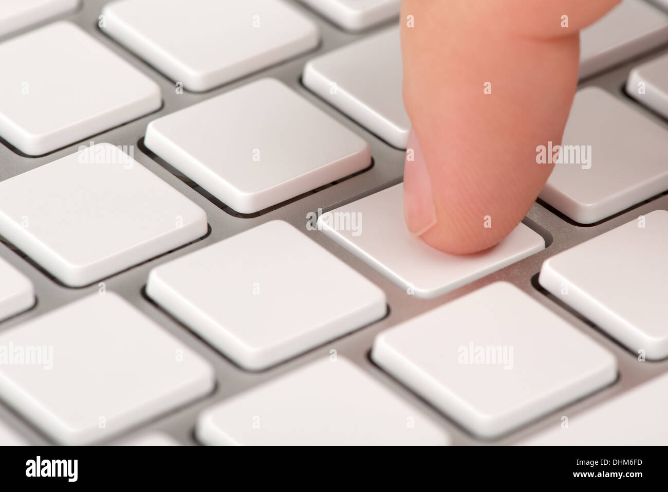 Close-up Zeigefinger drängt eine leere Computer-Tastatur mit Bokeh-Effekt Stockfoto