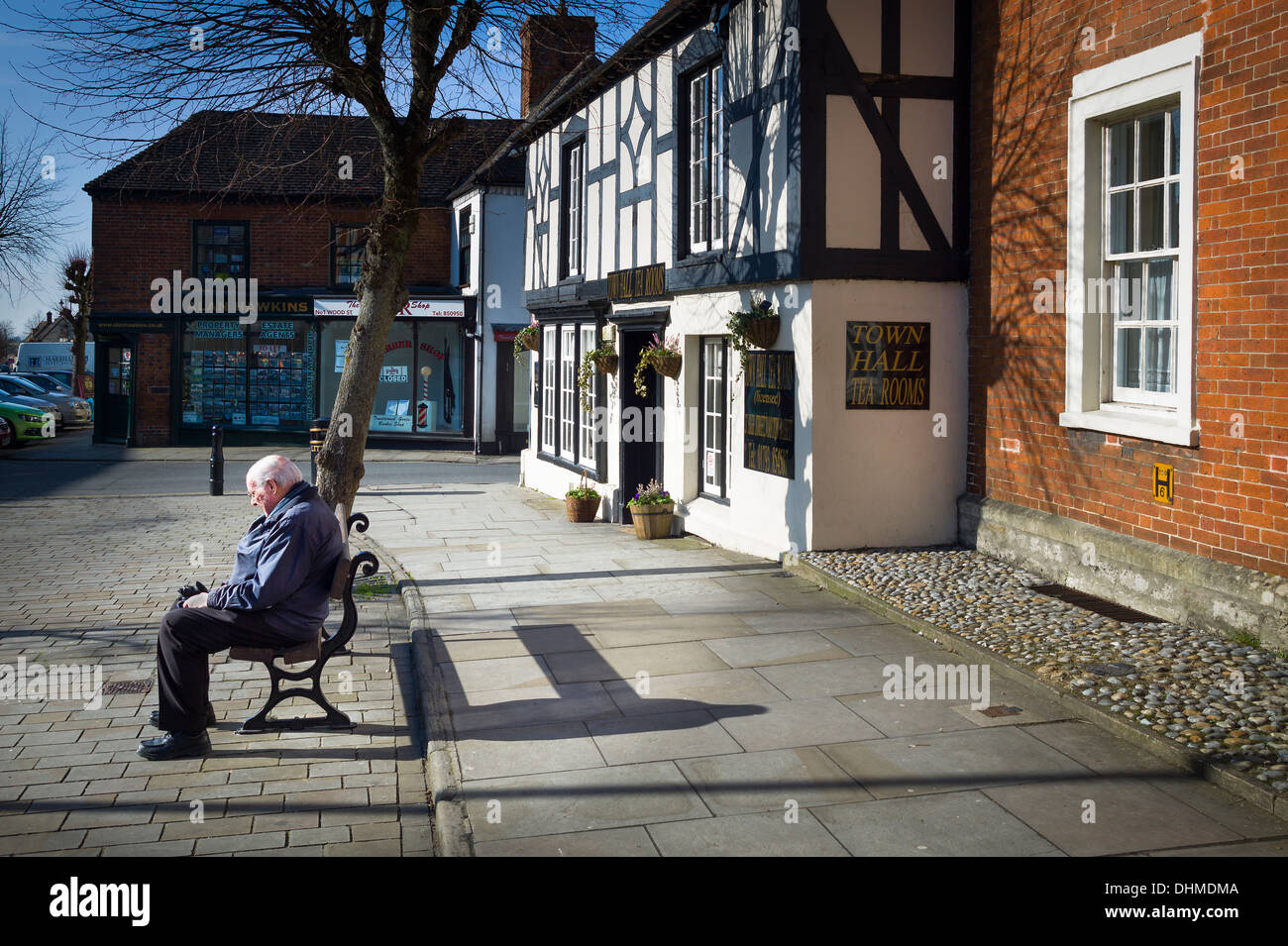 Ältere einsame Mann sitzt im Royal Wootton Bassett in einer ruhigen Sonntagmorgen Stockfoto