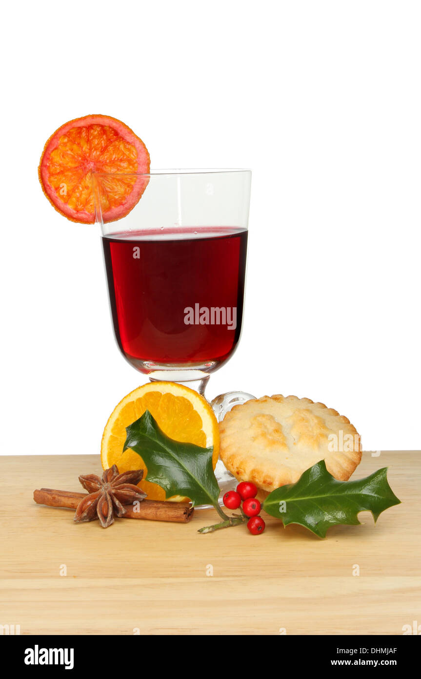 Glühwein, Mince Pie und Holly auf einem Holzbrett vor einem weißen Hintergrund Stockfoto